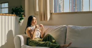 Woman peacefully enjoying tea on the couch after a relaxation hypnosis session in Edmonton.